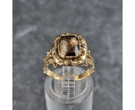 A Georgian yellow metal foiled quartz ring, in a chased scroll setting with pierced scroll shoulders, size N-O.