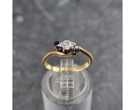 A yellow metal diamond and sapphire three stone ring, stamped 18ct &amp; plat, size K 1/2.