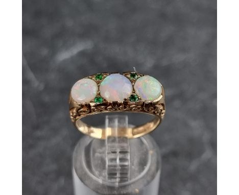 A 9ct gold opal and emerald ring, set three opals and four small emeralds, London 1975, size M 1/2, gross weight 4.5g.