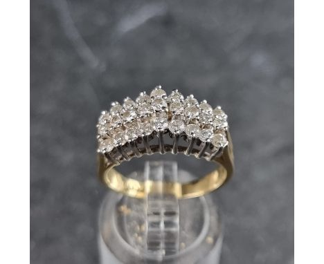A diamond twenty seven stone ring, the diamonds set in three rows and in an arched setting, stamped 14k, size O.