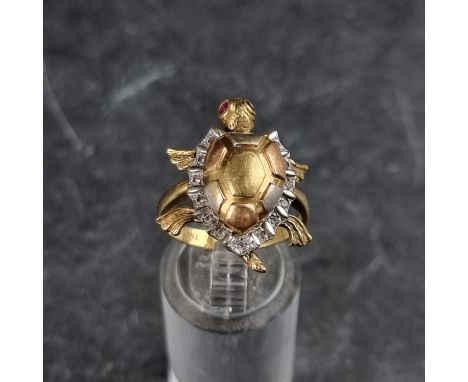 A yellow metal diamond and ruby novelty turtle ring, with movable limbs and head and hinged shell, stamped 750, size P.