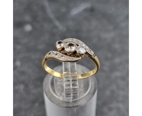 A diamond crossover ring, set three central diamonds with a further four diamonds to each side, stamped 18ct/plat, size O.