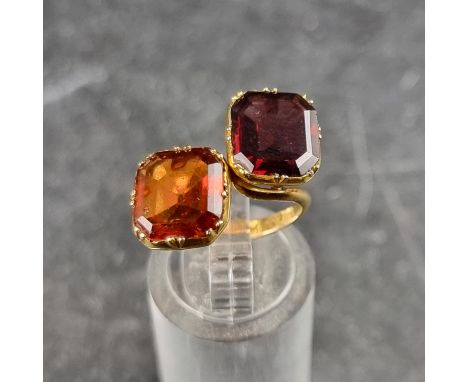 A yellow metal crossover, ring set two faceted gemstones, stamped F J and 14k, size J.
