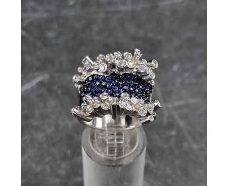 A sapphire and diamond cocktail ring, stamped 18k, set multiple small diamonds and sapphires, size O.