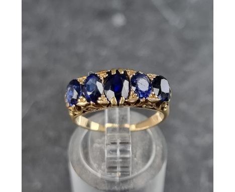 A sapphire five stone ring, in a yellow metal setting, size H1/2.