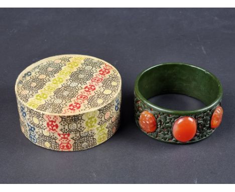 A vintage Chinese green and red lacquer bangle, set with three carnelians, 75mm diameter, in original box.
