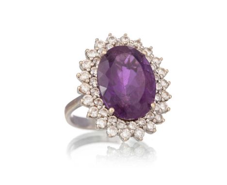 AMETHYST AND DIAMOND RING, set with an oval amethyst of approximately 9.48 carats, within a diamond halo totalling approximat