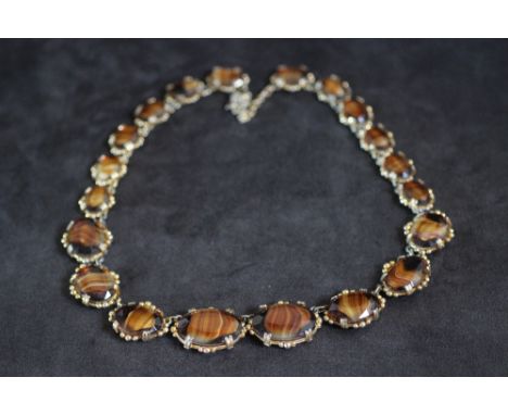 A VINTAGE TIGERS EYE STYLE AGATE NECKLACE, in a gilt mount