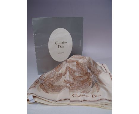 A VINTAGE CHRISTIAN DIOR SILK SCARF, neutral tones with palm tree style pattern, approximately 68 x 68 cm, with original pack