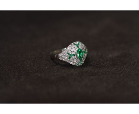 A PLATINUM VICTORIAN STYLE EMERALD AND DIAMOND DRESS RING, set with a central oval shaped emerald, Ring size M 1/2