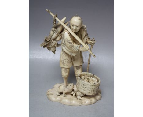 A JAPANESE IVORY OKIMONO, depicting a fruit seller holding a rod over his shoulder with his fruit / veg, the other hand holdi