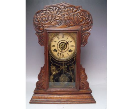 AN ANTIQUE OAK 'GINGERBREAD' MANTLE CLOCK OF TYPICAL FORM, with paper label to reverse, key, pendulum, H 56 cm