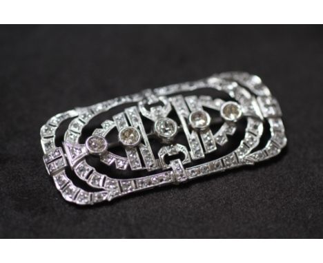 AN EDWARDIAN PLATINUM DIAMOND BROOCH WITH FILIGREE DESIGN, in a vintage box. Set with 5 graduated old-cut diamonds and severa