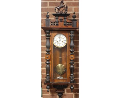 A 19TH CENTURY MAHOGANY VIENNA WALLCLOCK, with rearing horse surmount, the enamel dial with Roman numerals, pendulum and key,