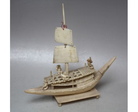 A LATE 19TH / EARLY 20TH CENTURY IVORY CARVED JUNK WITH FISHERMAN, raised on a rectangular plinth and four feet, H 18.5 cm, L