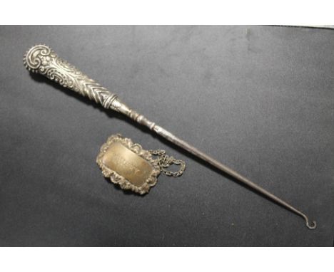 A LARGE SILVER HANDLED BUTTON HOOK AND SILVER WINE LABEL