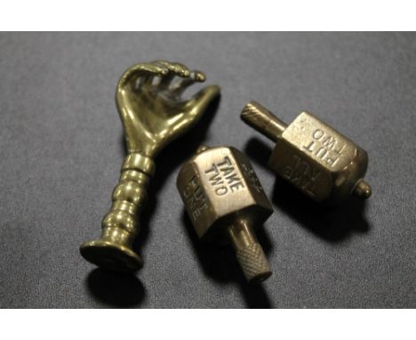 AN UNUSUAL ANTIQUE PIPE TAMPER IN THE FORM OF A HAND TOGETHER WITH TWO PUT AND TAKE SPINNERS 