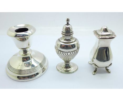 Two silver pepperettes, one marked Harrods, and a silver candlestick, pepperettes 92g 