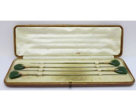 A cased set of four yellow metal mounted and jade hat pins 