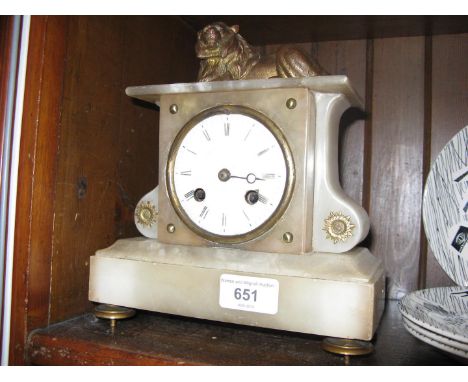 A French late 19th century alabaster mantel clock with lion finial, height 22cm. 