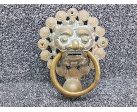 A Chinese heavy brass knocker in the form of a dragon Foo dog 22cm high.