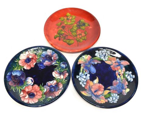 Three Moorcroft plates Three Moorcroft plates, two anemone pattern plates on a blue ground and one flambe plate, painted and 