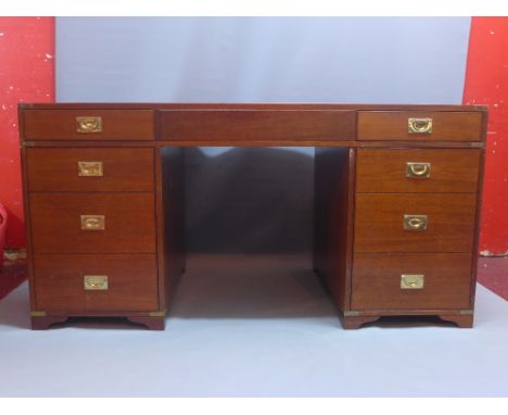 A campaign style mahogany pedestal desk with an arrangement of eight drawers, raised on carved bracket feet. H-75cm, W-150cm,