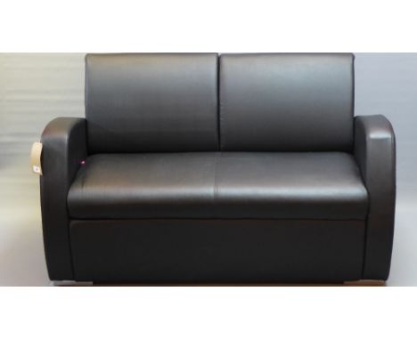 An Art Deco style two seater black leather sofa raised on block feet