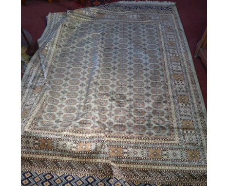 A Bokhara style carpet with elephant pad motifs on a green ground contained by borders. 280cm X 200cm