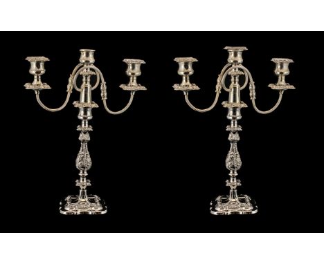 A Pair of Silver Plated Decorative Two Branch Three Light Candleabras of molded floral and scroll construction on square shap