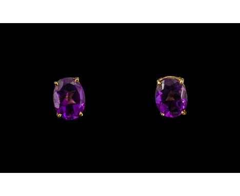 Pair of Oval Shaped Amethyst Set Stud Earrings, length 8 mm.For pierced ears, screw back, marked 14k.