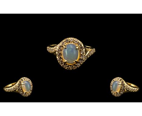 Natural Opal and Zircon Halo Ring, a 1.5ct oval cut opal cabochon, framed with round cut natural white zircons, with a furthe
