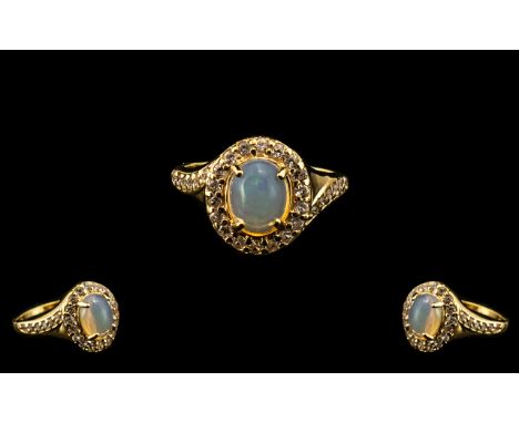 Natural Opal and Zircon Halo Ring, a 1.5ct oval cut opal cabochon, framed with round cut natural white zircons, with a furthe