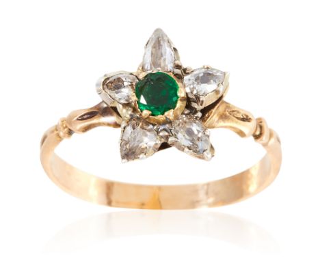 AN ANTIQUE EMERALD AND DIAMOND RING in high carat yellow gold, depicting a flower set with a round cut emerald and pear cut d