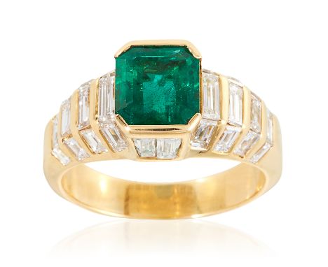 AN EMERALD AND DIAMOND RING in 18ct yellow gold, the 2.14 carat step cut emerald between jewelled diamond shoulders and galle