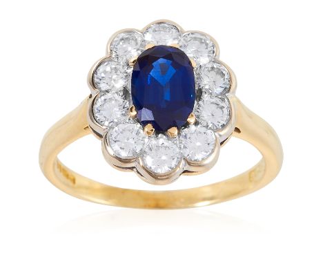 A SAPPHIRE AND DIAMOND CLUSTER RING in 18ct yellow gold, the 1.01 carat oval cut sapphire encircled by diamonds totalling app