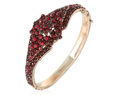 AN ANTIQUE GARNET BANGLE jewelled with rose cut garnets, unmarked, 5.5cm inner diameter, 20.6g.