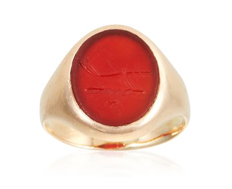 AN ANTIQUE CARNELIAN INTAGLIO SIGNET RING in high carat yellow gold, set with an oval piece of carnelian with an engraved her