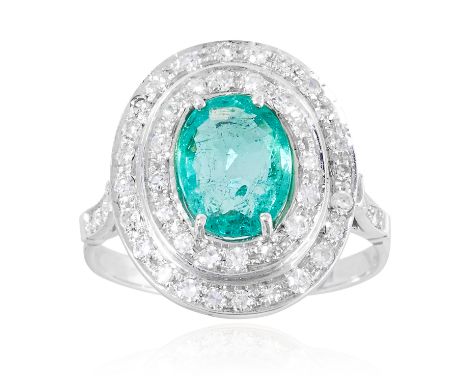 AN EMERALD AND DIAMOND CLUSTER RING in platinum or white gold, the oval cut emerald encircled by a double halo of diamonds, u