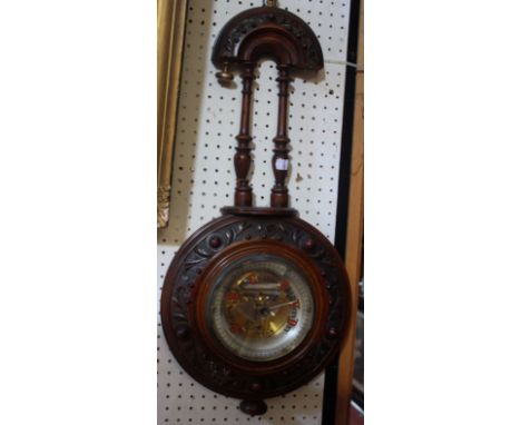 A late Victorian aneroid barometer in a fancy carved mahogany case and partly coloured dial, height 70cm