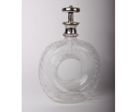 A novelty cut glass whisky decanter in the form of a tyre, engraved 'When Tyred, Scotch', with silver collar and stopper in t