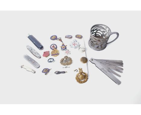 A mixed lot including, cutlery, enamel and other badges, pen knives and brass candle sticks etc.