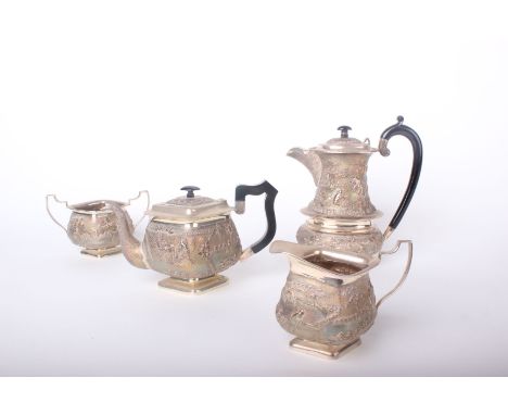 An Far Eastern/Indian white metal lozenge-shaped three piece tea service profusely embossed with animals and figures in rural