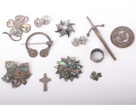 A collection of silver and white metal jewellery including a Scottish Celtic silver penannular brooch, another similar round 