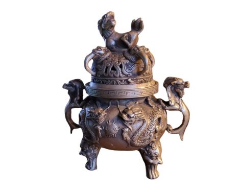 A Chinese patinated bronze koro and cover, temple lion finial, cast in relief with dragons chasing the flaming pearl, dragon 