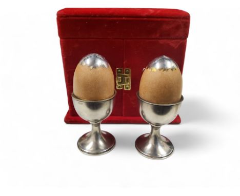 Anthony Elson - a pair of silver and silver gilt trompe l'oeil egg in an egg cup salt and pepper pots, 10cm high, London 1987