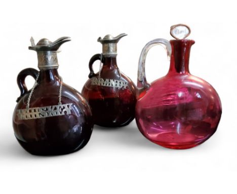 A pair of 19th century amber glass flattened mallet shaped decanters, scroll handles, plated hinged covers, 19.5cm high, c.18