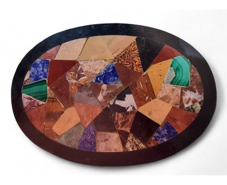 An Italian Grand Tour micro-mosaic oval black marble desk weight, inlaid with malachite, fossil stone, alabaster and other sp