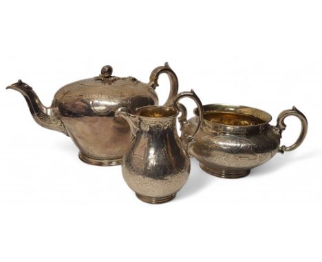 A Victorian silver three piece tea service, of ovoid from, engraved and chased with anthemions and scrolls, bud and leaf fini
