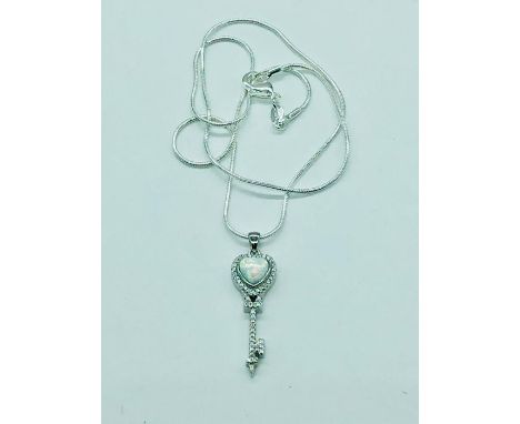 A silver and opal key pendant necklace on silver chain